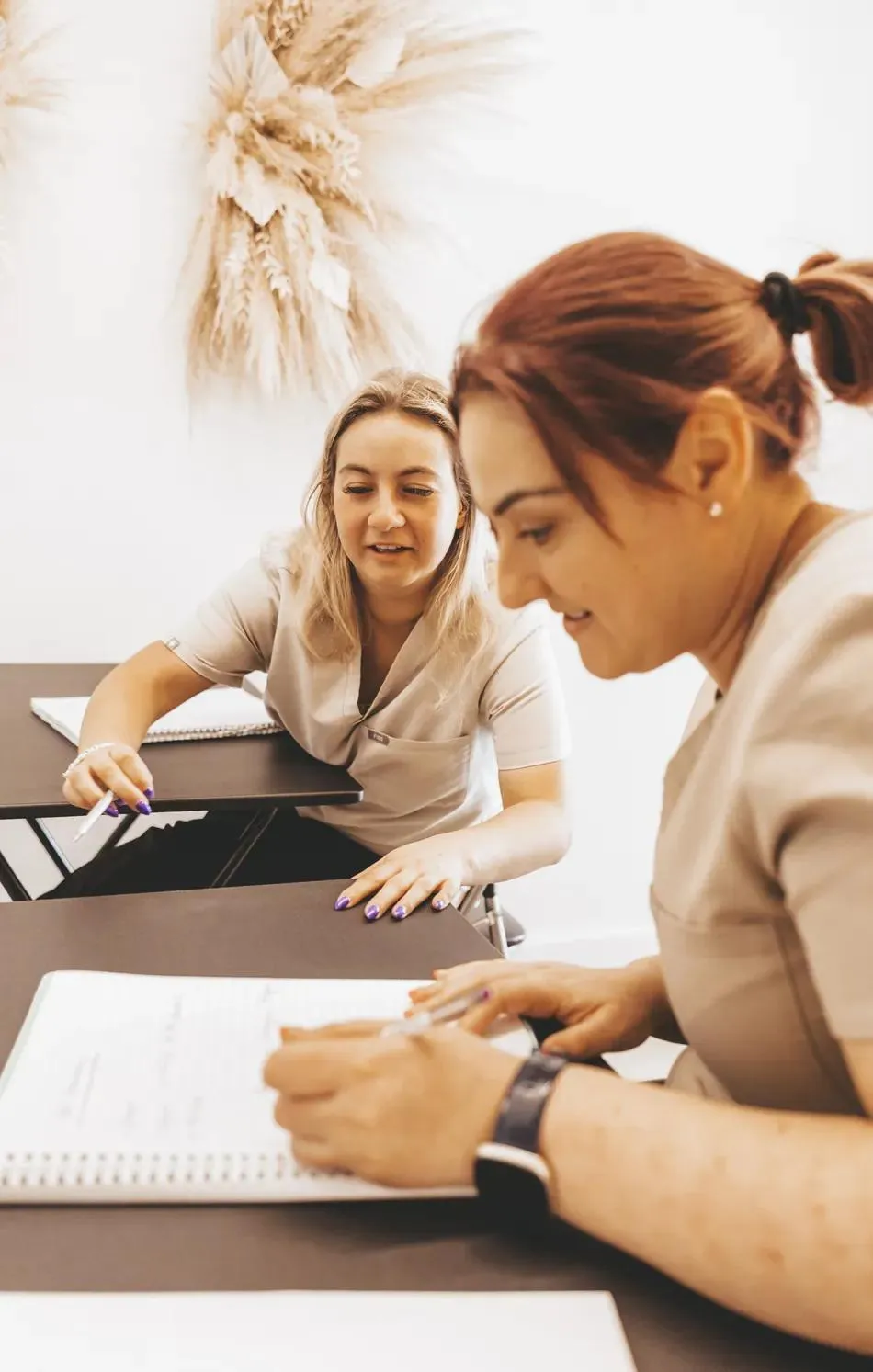 Sarah guiding a student through course notes at the academy