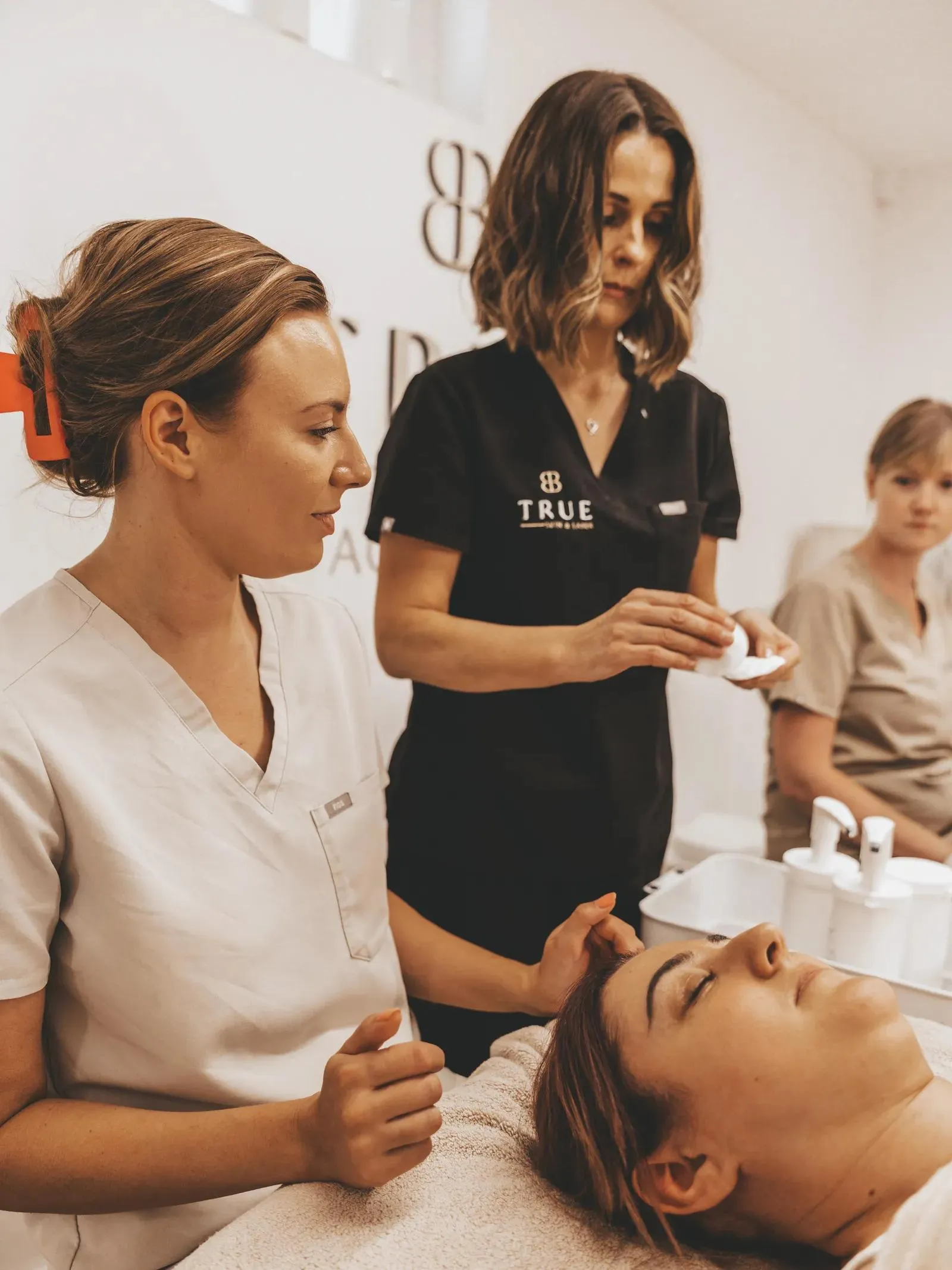 Sarah supervising a student carrying out a facial treatment during training at the academy